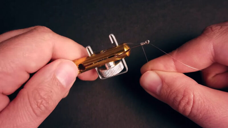 Man using Knot Tying Tool for Snelling Fish Hooks , only hands